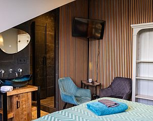 Slaapkamer in ZH415 vakantiehuis, Ouddorp, Zuid-Holland met modern interieur en comfortabele zitplek.