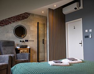 Stijlvolle slaapkamer in ZH415 vakantiehuis, Ouddorp, Zuid-Holland met comfortabele fauteuils.