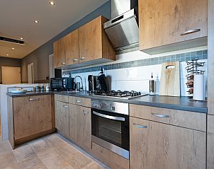 Moderne keuken in ZH415 vakantiehuis, Ouddorp, Goeree-Overflakkee met houten kasten en apparatuur.