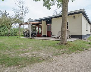 Bungalow Stellendam in Ouddorp, Goeree-Overflakkee, biedt een rustige vakantiehuiservaring met een uitnodigend terras en groene omgeving.