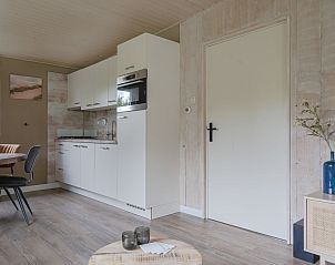 Moderne keuken in Bungalow Stellendam, een vakantiehuis in Ouddorp, Goeree-Overflakkee, Zuid-Holland, met strakke inrichting en gezellige sfeer.