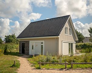 Gemtliche Sitzecke im Strand Resort Ouddorp Duin, 6-Personen-Villa Springerduin, Ouddorp, mit bequemen Sesseln und stimmungsvoller Beleuchtung.