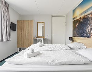 Grote eettafel met uitzicht op duinen in Strand Resort Ouddorp Duin, 10-persoons villa in Ouddorp.