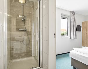 Zonnig terras met ligstoelen in Strand Resort Ouddorp Duin, 10-persoons villa in Ouddorp, Zuid-Holland.