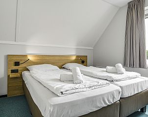 Slaapkamer met tweepersoonsbed en stranddecor in Strand Resort Ouddorp Duin, 10-persoons villa in Ouddorp.