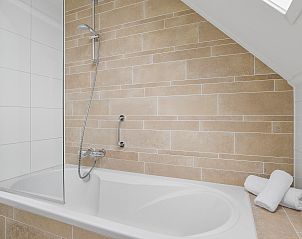 Moderne badkamer naast slaapkamer in Strand Resort Ouddorp Duin, 10-persoons villa in Ouddorp.