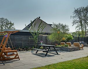 Gemtliche Terrasse mit Schaukelstuhl im Ferienhaus De Toekomst 107 'Sista' in Ouddorp, ideal fr einen entspannten Nachmittag.