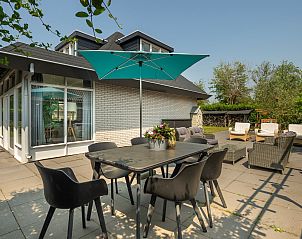 Sitzplatz im Freien mit Sonnenschirm im Ferienhaus De Toekomst 107 'Sista' in Ouddorp, ideal fr Sommertage.