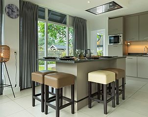 Kche mit Barhockern im Ferienhaus De Toekomst 107 'Sista' in Ouddorp, ideal fr gemtliche Mahlzeiten.