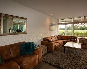 Helles Wohnzimmer im Ferienhaus De Toekomst 126 Beachgarden in Ouddorp mit groen Fenstern.