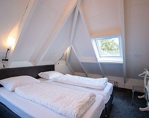 Gemtliches Schlafzimmer mit Dachfenster im Ferienhaus De Toekomst 126 Beachgarden in Ouddorp.