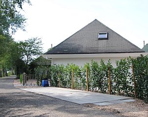 Eingang zum Ferienhaus De Toekomst 126 Beachgarden in Ouddorp mit grnem Zaun.