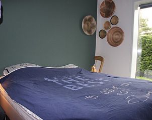 Comfortabele slaapkamer in vakantiehuis Zeeegel, Ouddorp, met groot raam en sfeervolle decoratie, Zuid-Holland.