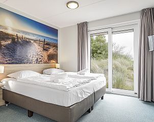 Speisesaal mit groem Tisch in der Villa im Strand Resort Ouddorp Duin, Goeree-Overflakkee.