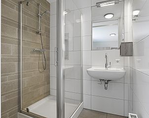 Slaapkamer in Strand Resort Ouddorp Duin | 8-persoons villa - Kijkduin, Ouddorp, met comfortabel bed en rustgevend natuurdecor.