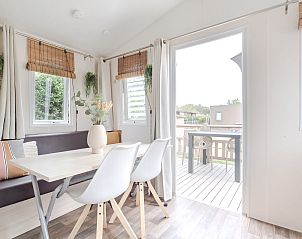 Cozy indoor area of Mobil home the Cormorant in Ouddorp, Goeree-Overflakkee overlooking the terrace and green surroundings.