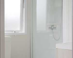 Modern bathroom in Mobil home de Aalscholver, mobile home in Ouddorp, Goeree-Overflakkee, South Holland, with sleek shower and window.