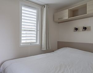 Cozy bedroom in Mobil home de Aalscholver, mobile home in Ouddorp, Goeree-Overflakkee, South Holland with comfortable bed.