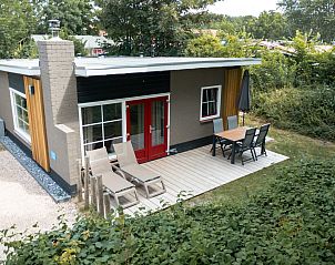 Terrace at Bungalow Middelharnis in Ouddorp, Goeree-Overflakkee with comfortable deck chairs and dining table.