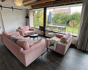 Gezellige woonkamer van VZ934 Bungalow in Ouddorp met uitzicht op de tuin in Zuid-Holland.