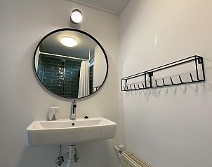 Moderne wastafel en spiegel in de badkamer van VZ934 Bungalow in Ouddorp, gelegen in Zuid-Holland.