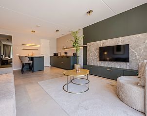 Sonniges Wohnzimmer mit groen Fenstern in der 2-Bett-Wohnung 2L, Ouddorp, Goeree-Overflakkee, mit Blick auf die Dnen.