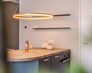 Gerumige Terrasse der 2-Bett-Wohnung 2L in Ouddorp, Goeree-Overflakkee, mit Sonnenschirm und bequemen Auensthlen.