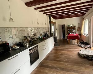 Moderne Kche im Ferienhaus in Goedereede, Goeree-Overflakkee, mit Esstisch und Holzboden.