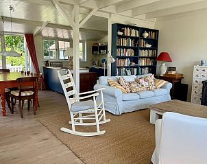 Gezellige woonkamer in Vakantiehuisje in Goedereede met open haard en boekenplank.