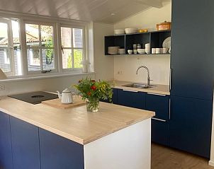 Moderne keuken in Vakantiehuisje in Goedereede met blauwe kasten en lichte werkbladen.