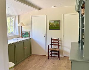 Hal in Vakantiehuisje in Goedereede met groene kasten en houten stoel in Zuid-Holland.