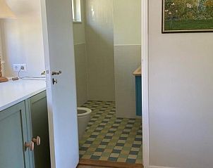 Badkamer in Vakantiehuisje in Goedereede met betegelde vloer en moderne voorzieningen.