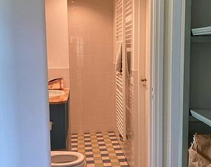 Slaapkamer in Vakantiehuisje in Goedereede met tweepersoonsbed en uitzicht op groene omgeving.