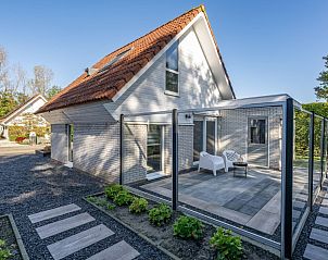Beach House 43 in Herkingen, Goeree-Overflakkee, een modern vakantiehuis met een ruime veranda en serene tuinomgeving.