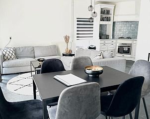 Moderne woonkamer van Beach House 43 in Herkingen, Goeree-Overflakkee. Stijlvol vakantiehuis met open keuken en comfortabele zithoek.
