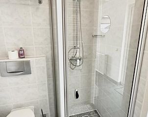 Moderne badkamer in Beach House 43, vakantiehuis in Herkingen, Goeree-Overflakkee, met stijlvolle douche en toilet.
