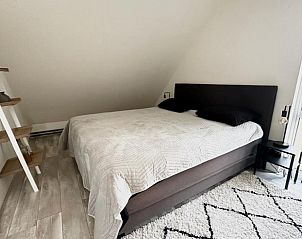 Gezellige slaapkamer in Beach House 43, een vakantiehuis in Herkingen, Goeree-Overflakkee, Zuid-Holland met modern interieur en veel licht.
