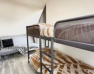 Slaapkamer in Beach House 43, Herkingen met stapelbed en comfortabele bank, ideaal voor een ontspannen vakantie in Zuid-Holland.