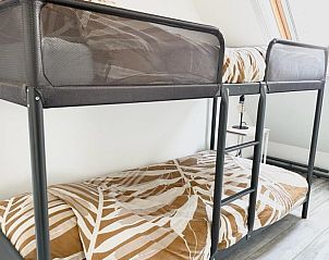 Sfeervolle slaapkamer in Beach House 43, Herkingen, Goeree-Overflakkee met stapelbed en natuurlijk lichtinval door dakraam.