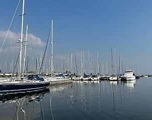 Uitzicht op de jachthaven bij Beach House 43 in Herkingen, Goeree-Overflakkee, een vakantiehuis omgeven door serene wateren en zeilboten.