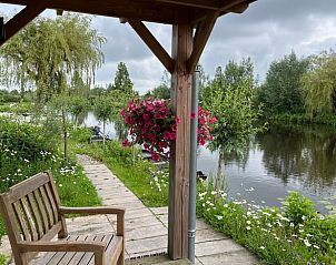 Veranda van Vakantiehuis in Reeuwijk met uitzicht op de serene natuur van het Groene Hart in Zuid-Holland.