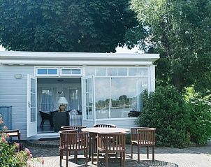 Vakantiehuisje in Reeuwijk met open deuren naar het terras, omgeven door groen in het Groene Hart.