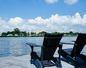 Ligstoelen op de steiger van Vakantiehuisje in Reeuwijk, met uitzicht over het meer in Zuid-Holland.