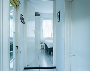 Hal naar de slaapkamer in Vakantiehuisje in Reeuwijk, Zuid-Holland, met lichtinval en moderne inrichting.