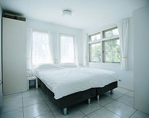 Comfortabele slaapkamer in Vakantiehuisje in Reeuwijk, Groene Hart, met grote ramen en veel licht.