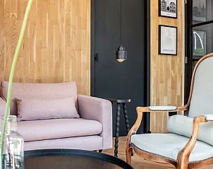 Cozy sitting area in Holiday home in Reeuwijk, Green Heart, South Holland, with stylish wooden walls and comfortable armchairs.