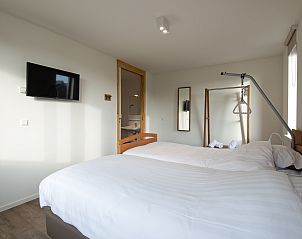 Slaapkamer met tweepersoonsbed in De Reeuwijkse Plassen bungalow, ideaal voor een ontspannen verblijf in Zuid-Holland.