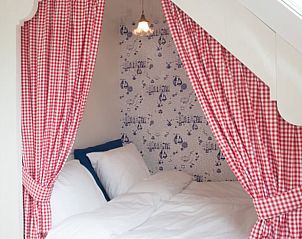 Knusse slaapkamer in Huisje in Haastrecht, vakantiehuis in Haastrecht, Zuid-Holland, met charmante gordijnen en decor.
