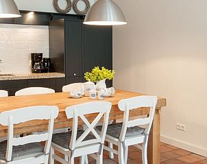 Gezellige eetkamer in Huisje in Haastrecht, Zuid-Holland, met houten tafel en lichte inrichting voor een huiselijk gevoel.