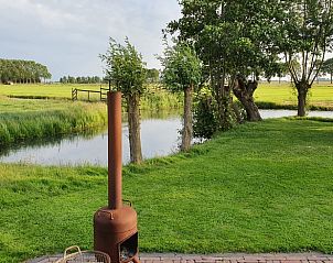 Uitzicht vanaf Huisje in Haastrecht, vakantiehuis in het Groene Hart, met prachtige grasvelden en een serene sfeer.